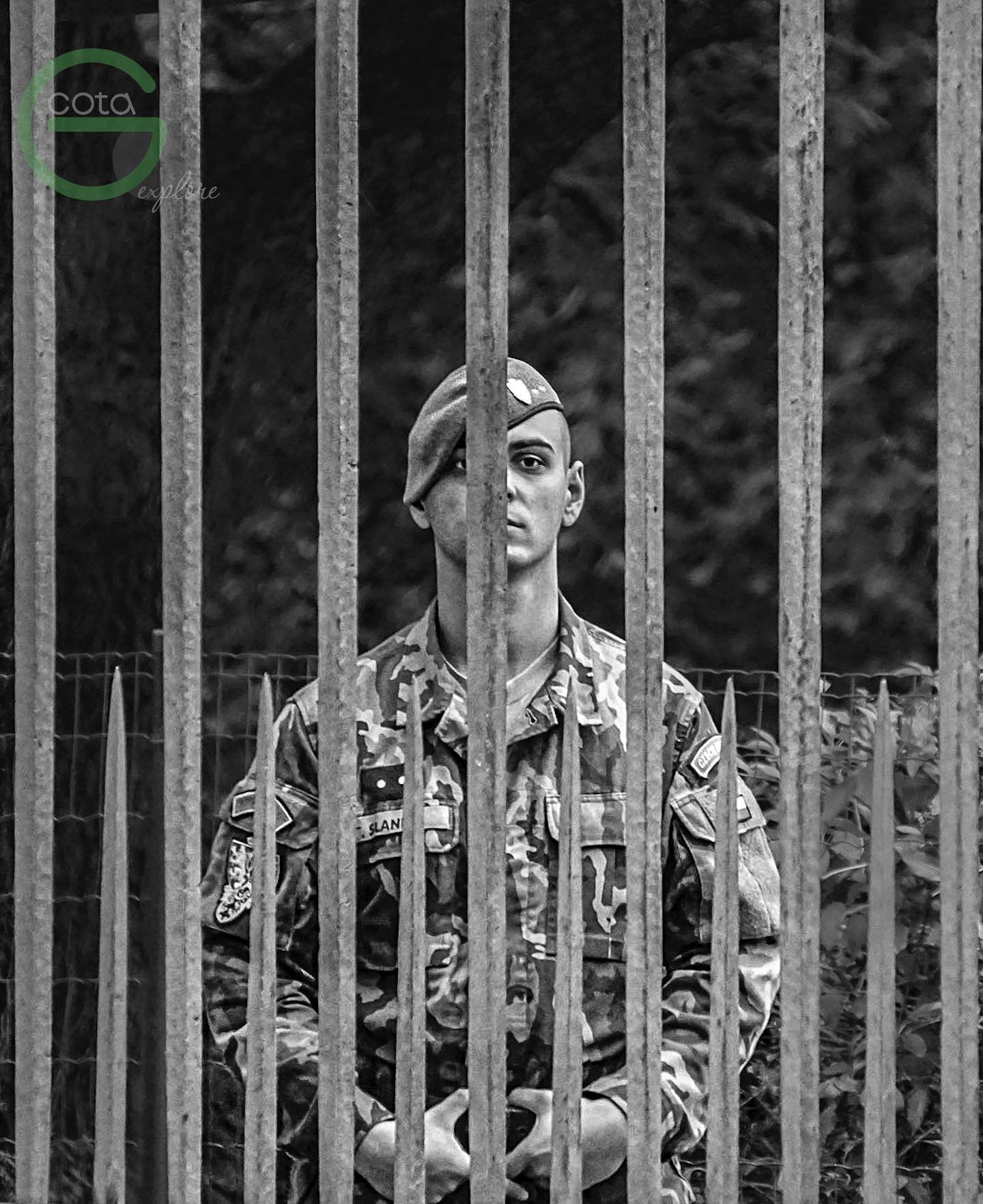 A person framed by a repeating vertical architectural pattern