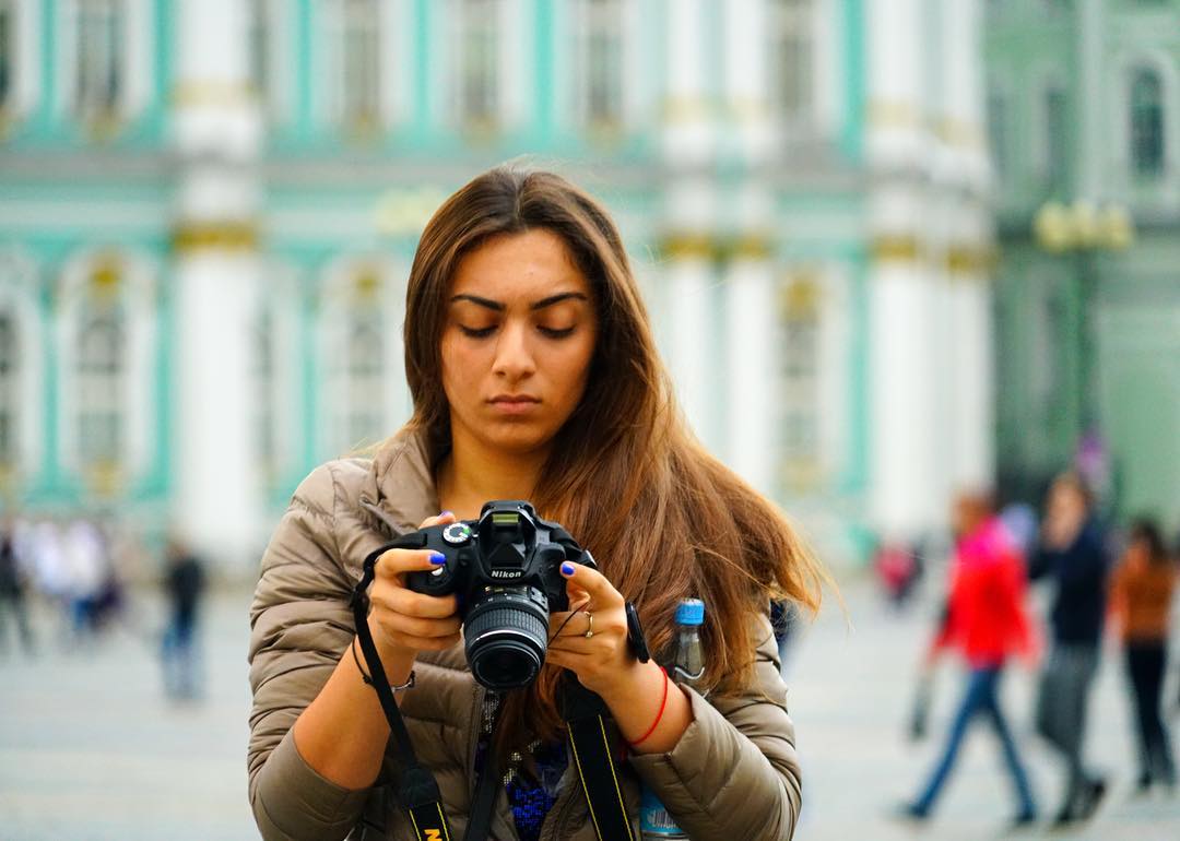 A photographer looking down at her camera