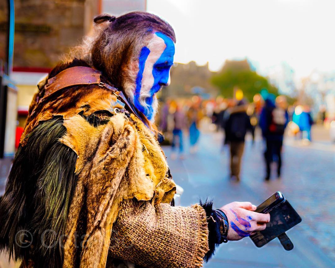 A costumed performer illuminated with vivid blue light